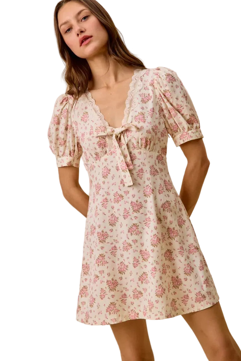 Cream floral mini dress with puff sleeves, lace V-neck trim, and bow tie
