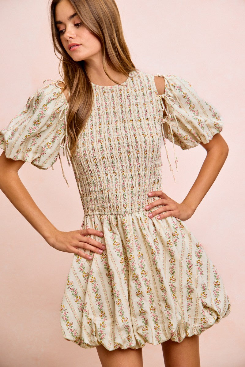 Ivory floral dress close view: smocked bodice, bow-tied puff sleeves, gathered waist
