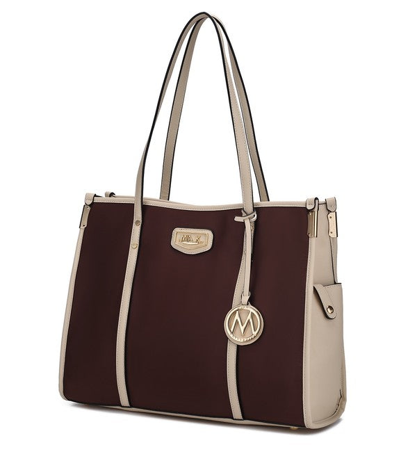 Oversized tote in dark brown with cream panels, front logo patch, top handles, side tassel charm