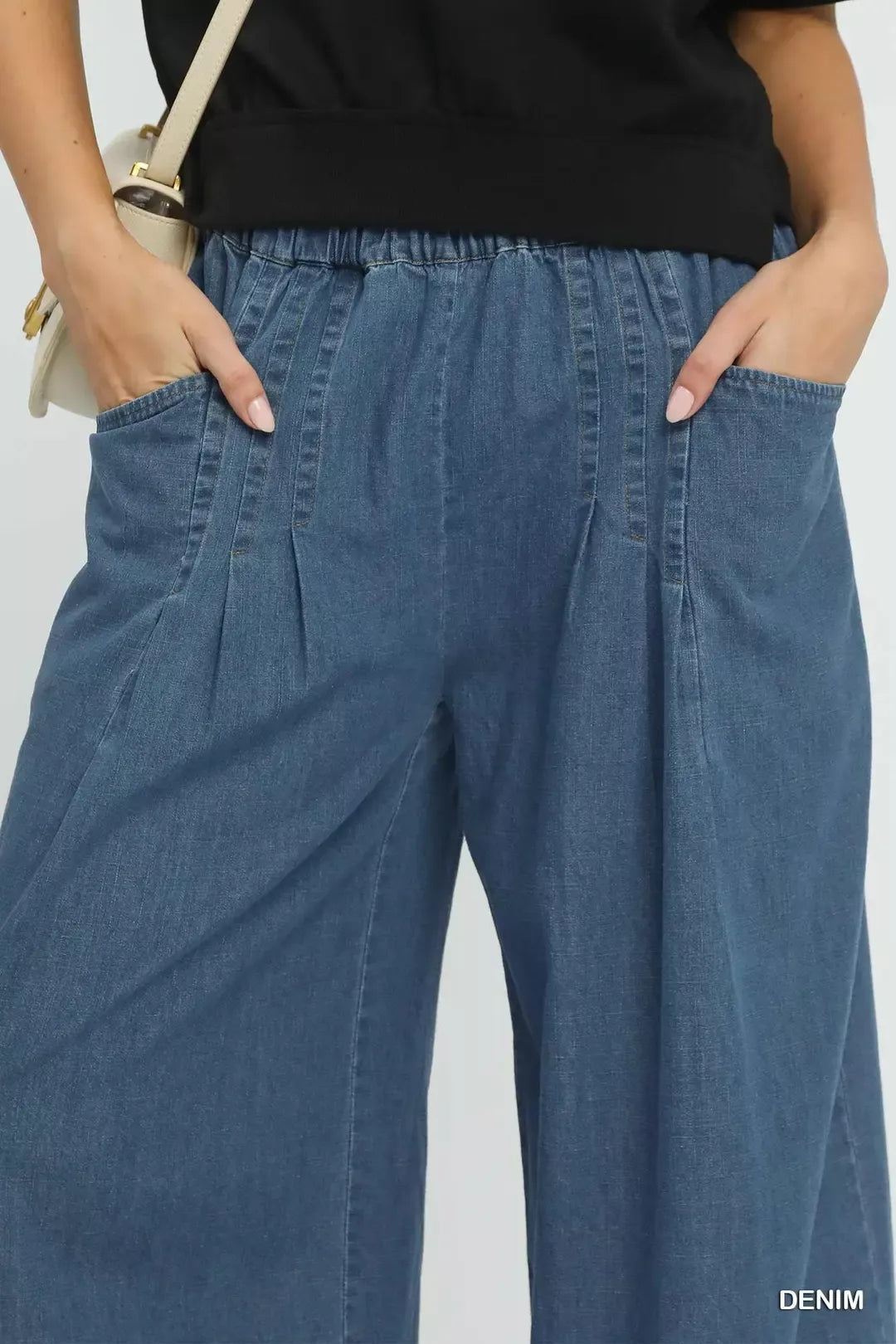 Stone-washed denim pants close-up: elastic waistband and vertical seam details
