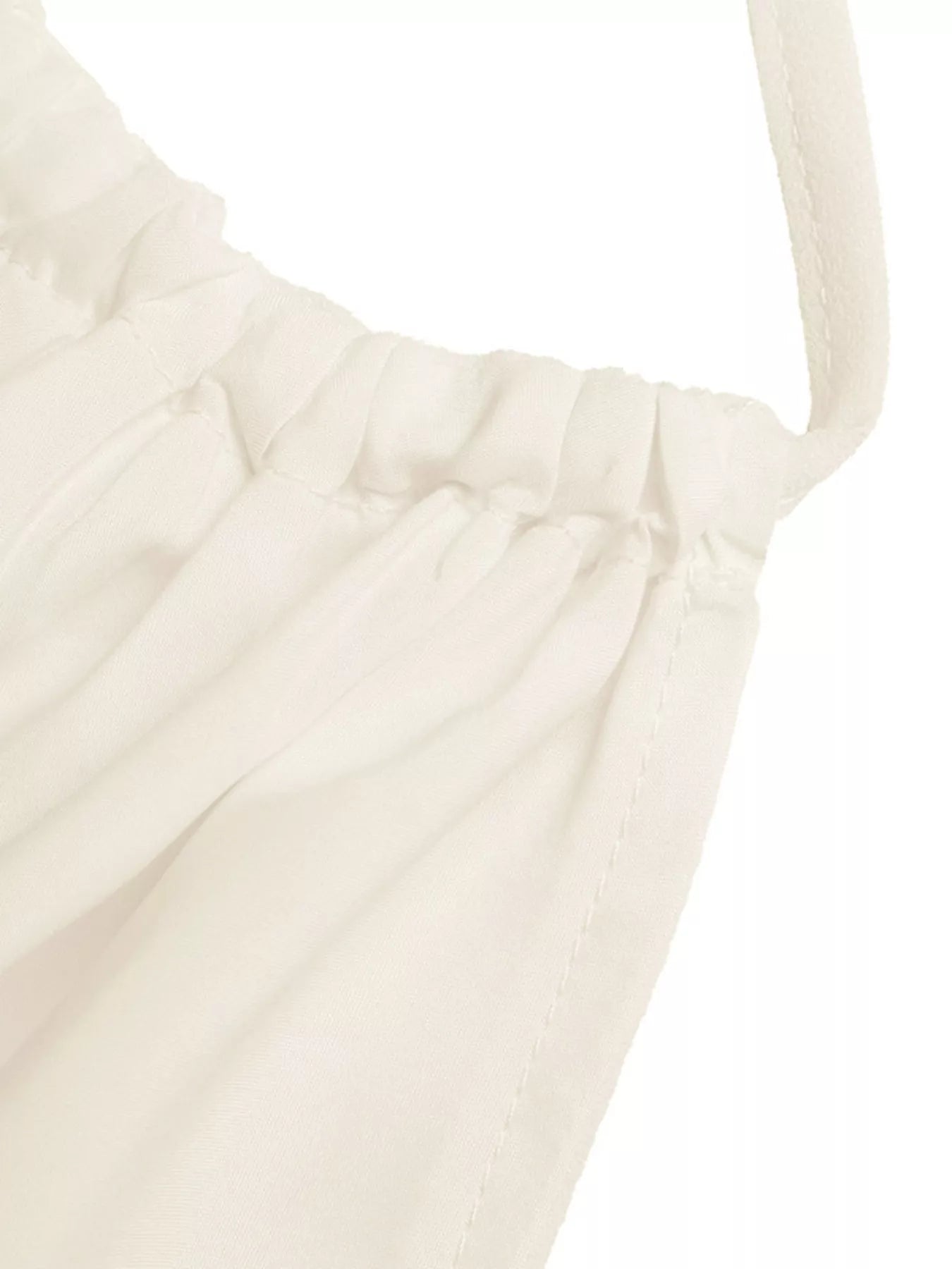 White tiered cami fabric close-up with pleated texture and gathered seam