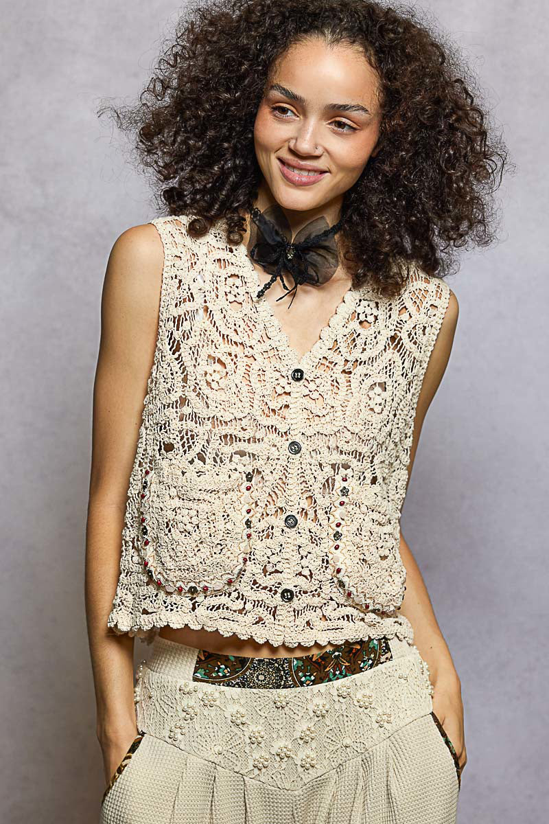 Natural beige crochet vest with scalloped edge, black bow collar, and button front