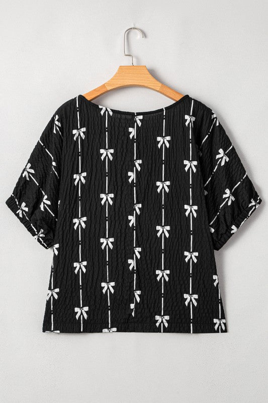 Black textured short puff-sleeve top, bow pattern with relaxed crew neck back