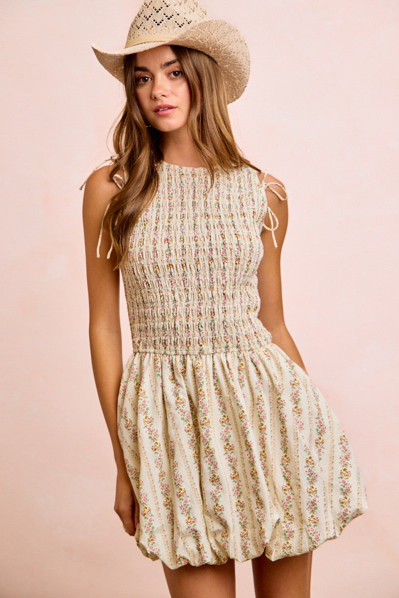 Ivory floral short dress with smocked bodice, tied puff sleeves, and flared tiered skirt