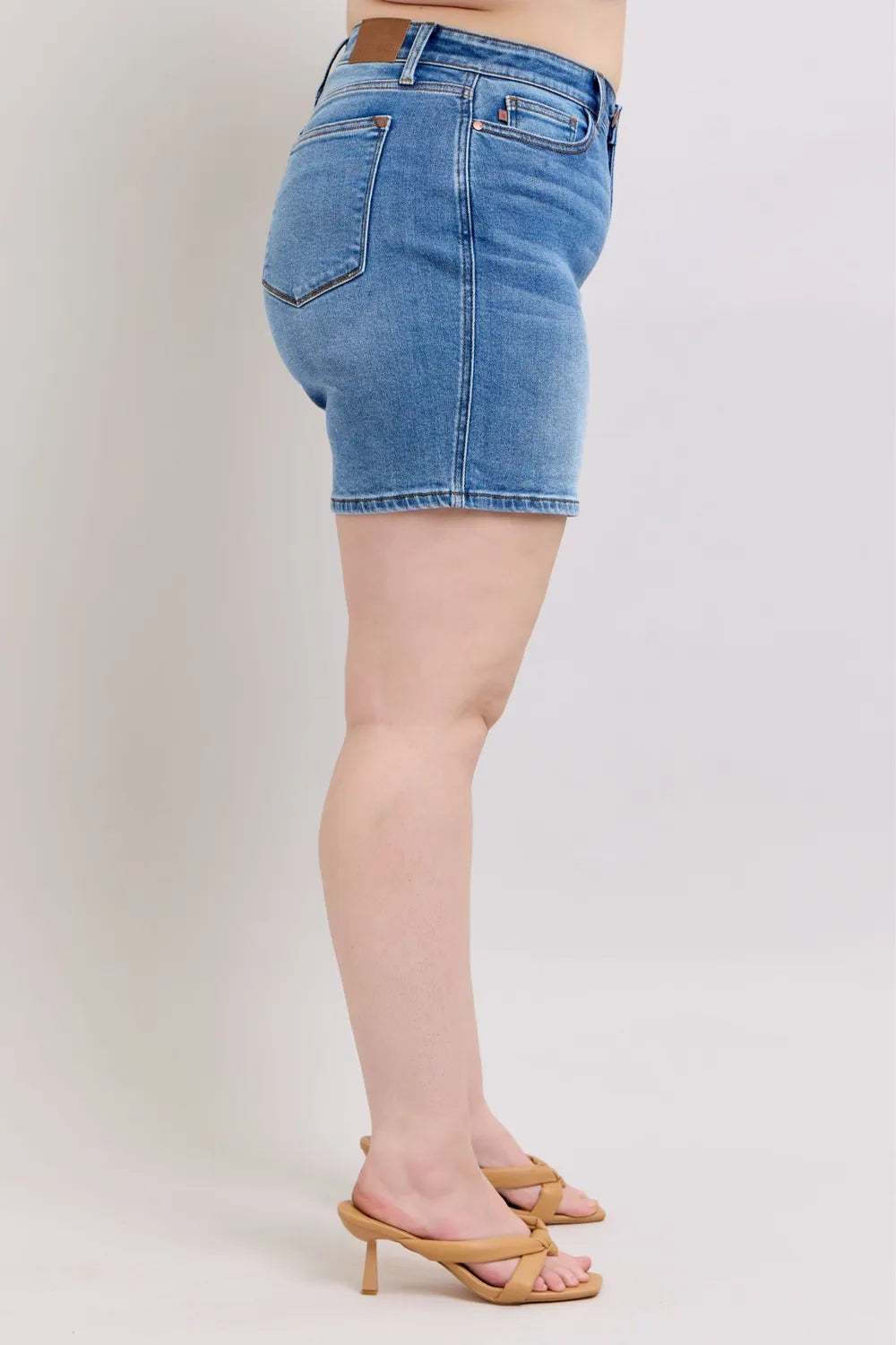 Medium wash denim shorts, back view with belt loops and stitched back pockets