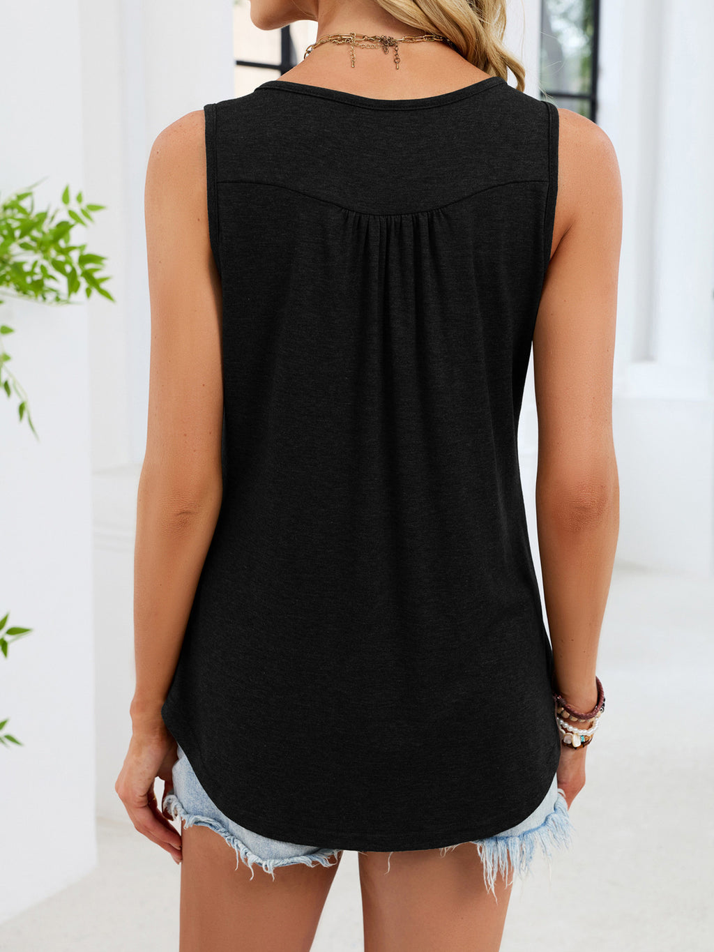 Back view button-detail round neck tank in black, sleeveless with curved hem