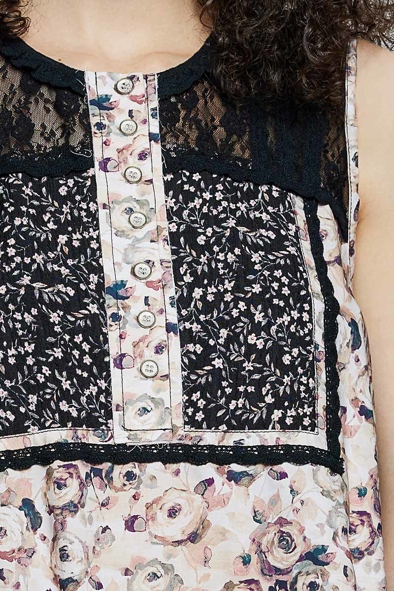 Button-front placket on black floral lace sleeveless top, printed vertical panel
