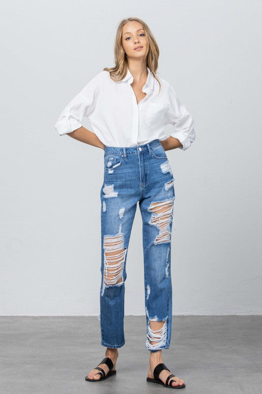 High-rise straight jeans, medium blue with frayed ripped panels at hips, knees