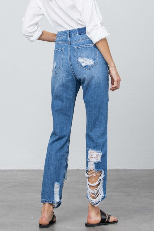 High-rise straight jeans front view, medium blue with torn patches at pocket and hem