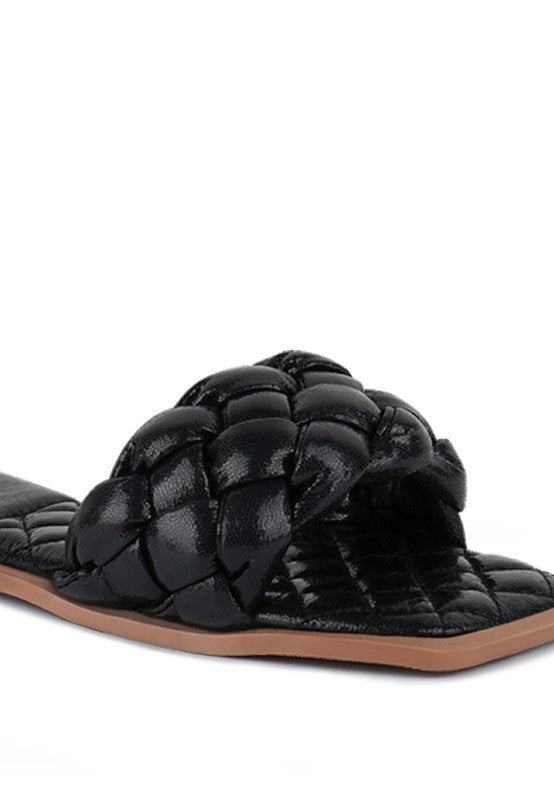 Close-up of black quilted strap with braided detail on patent PU slide