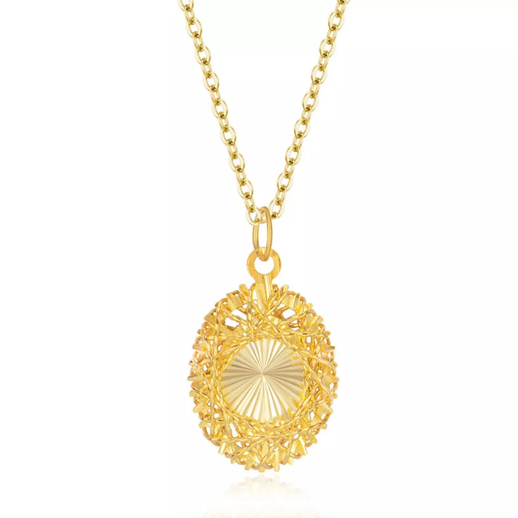 Gold pendant necklace close-up, round sunburst filigree charm on chain
