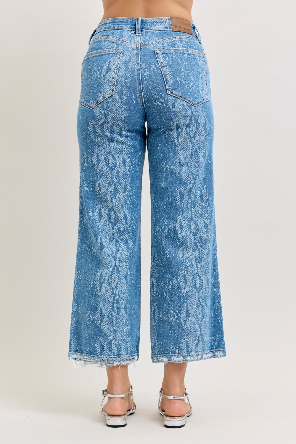 High-rise ankle wide-leg jeans, blue snake-print, frayed cropped hem.