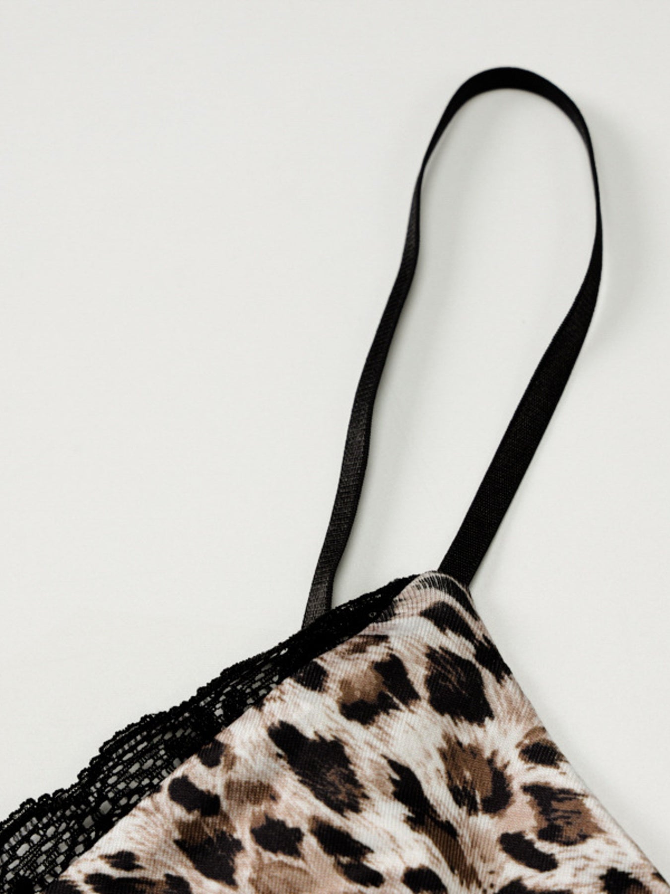 Close-up of leopard print cami spaghetti strap with black lace edging
