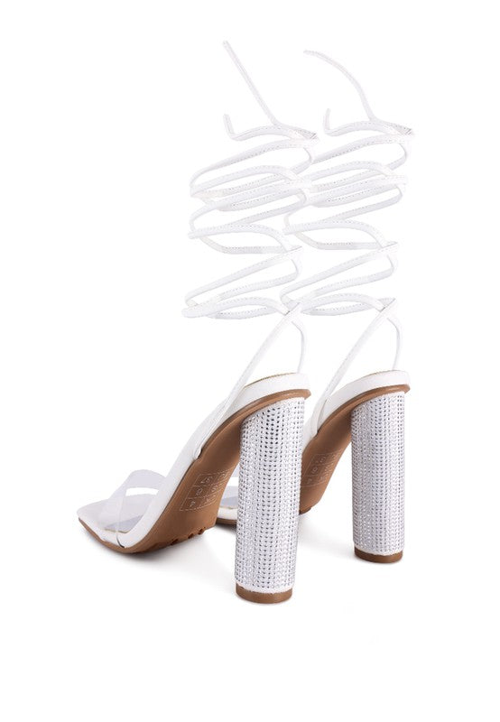 White lace-up high heel sandals showing side straps and tall jeweled heel