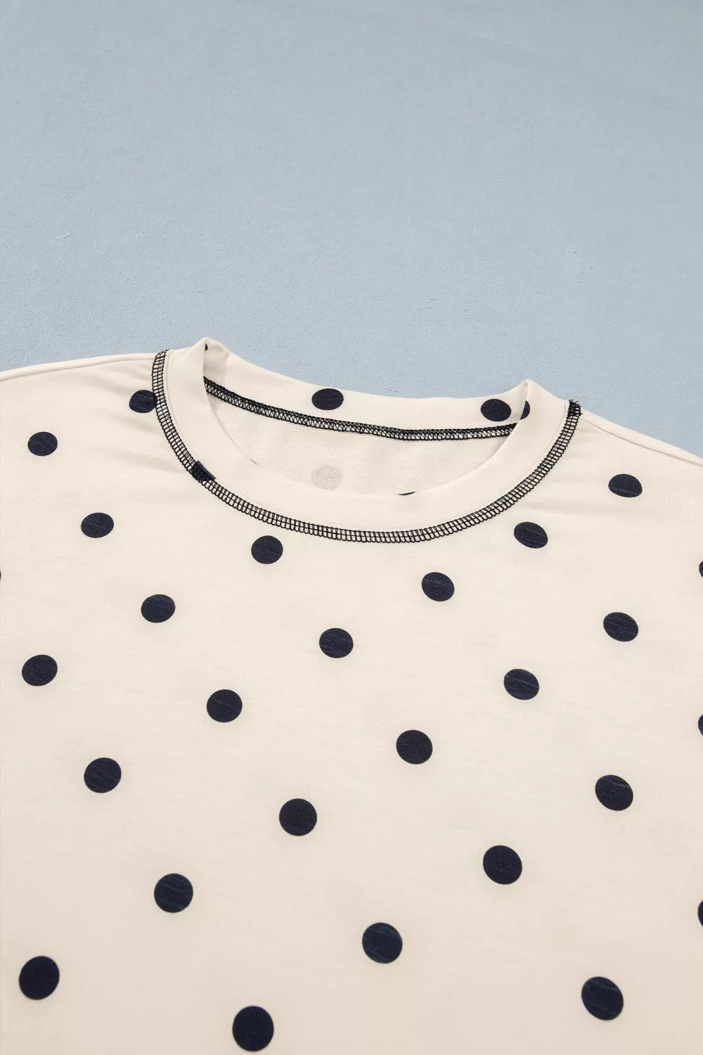 Cream T-shirt neckline with navy polka dots and contrast trim