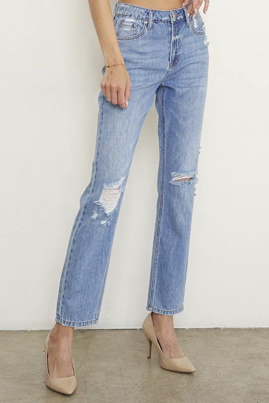 Close-up: high-rise girlfriend jeans, medium wash, ripped knee and frayed leg opening