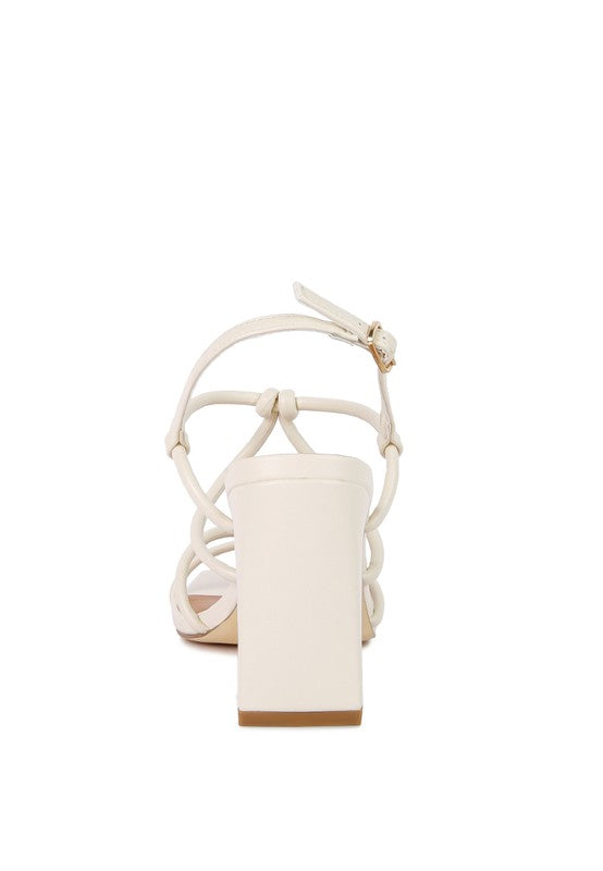 Cream block-heel sandal back view with ankle strap and knotted loops