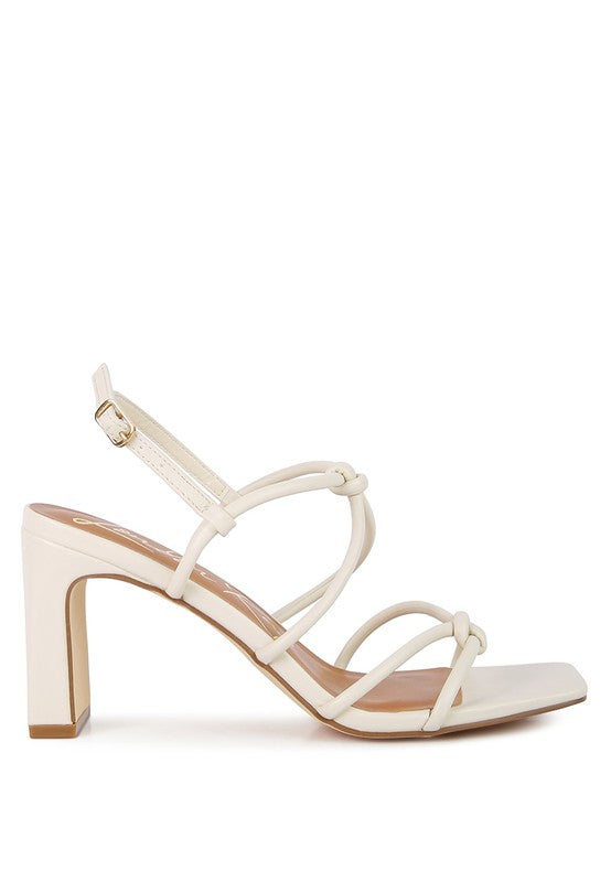 Cream open-toe sandal with knotted crossover straps and mid block heel