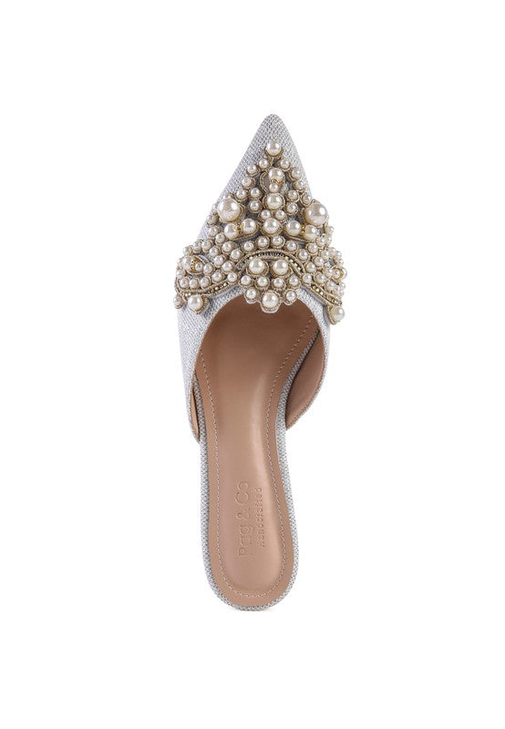 White pearl mules with tall embellished heel counter and textured upper