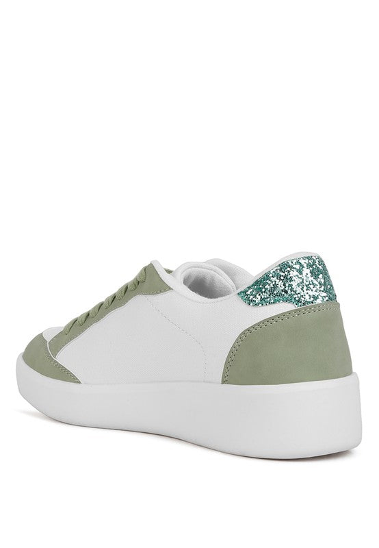 White Perry sneakers with green suede panels, glitter heel accent, and chunky sole