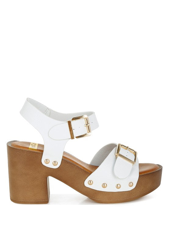 White leather heeled sandals with stud detail, gold buckles, and chunky platform sole