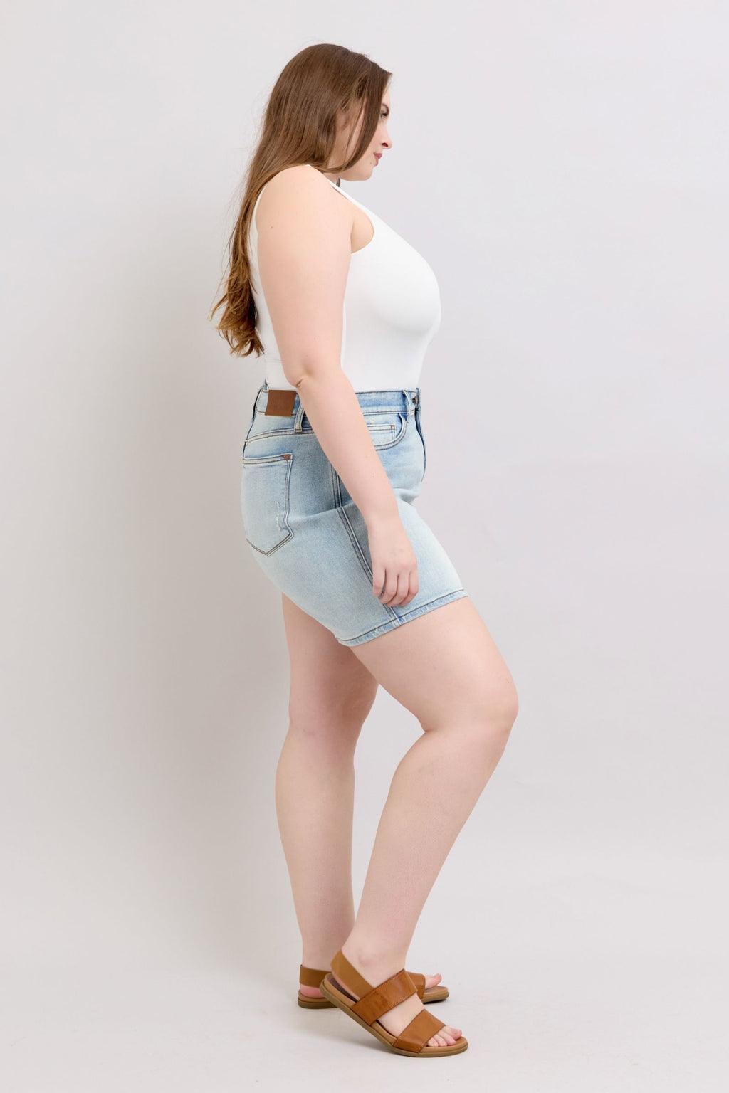 Light-wash denim shorts, side view, back pockets visible