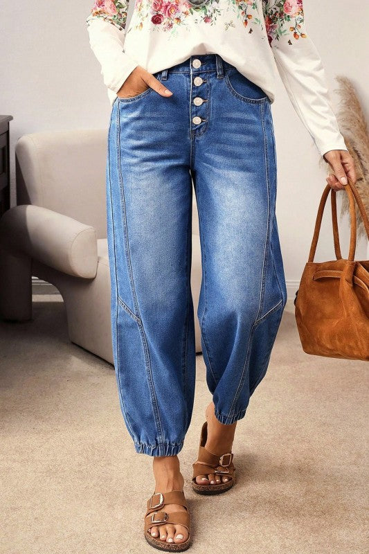 Blue denim jeans with buttoned fly and cuffed barrel legs, full view