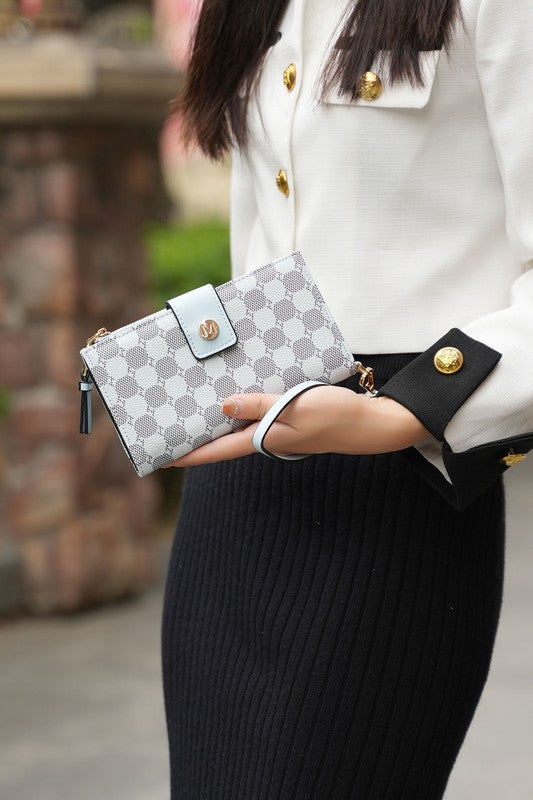 Solene wristlet wallet with white patterned exterior, wrist strap, and gold snap front