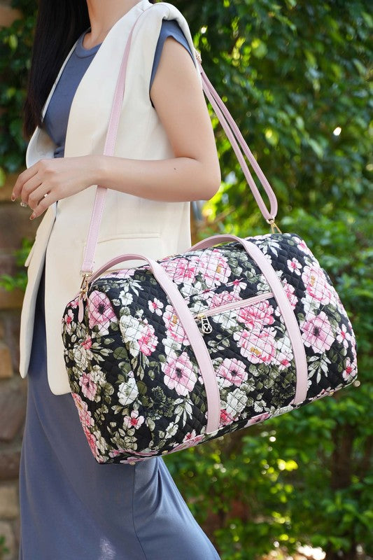 Quilted botanical duffle bag in dark floral with light pink trim and top handles