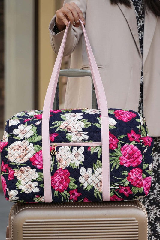 Botanical quilted duffle bag with long light pink strap and central front zip panel