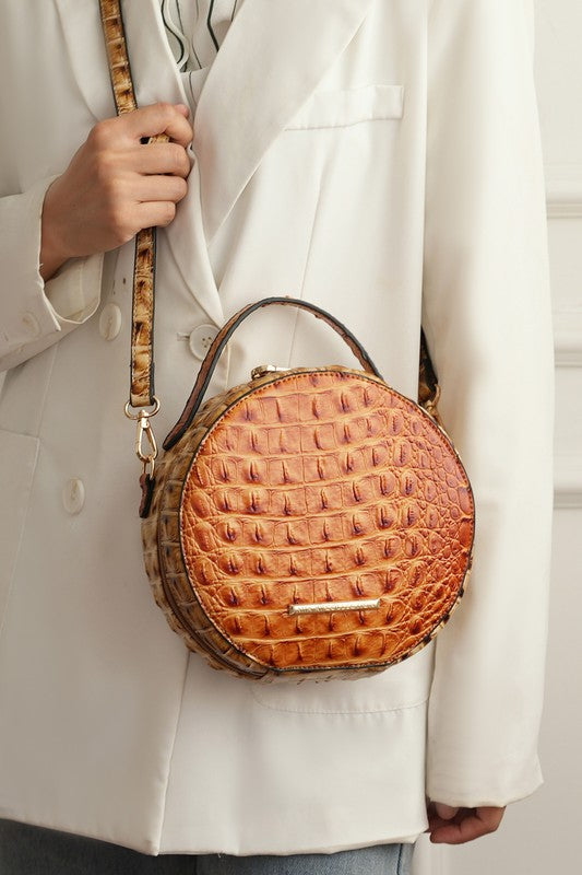 Croc-embossed round crossbody bag in cognac brown with top handle and strap