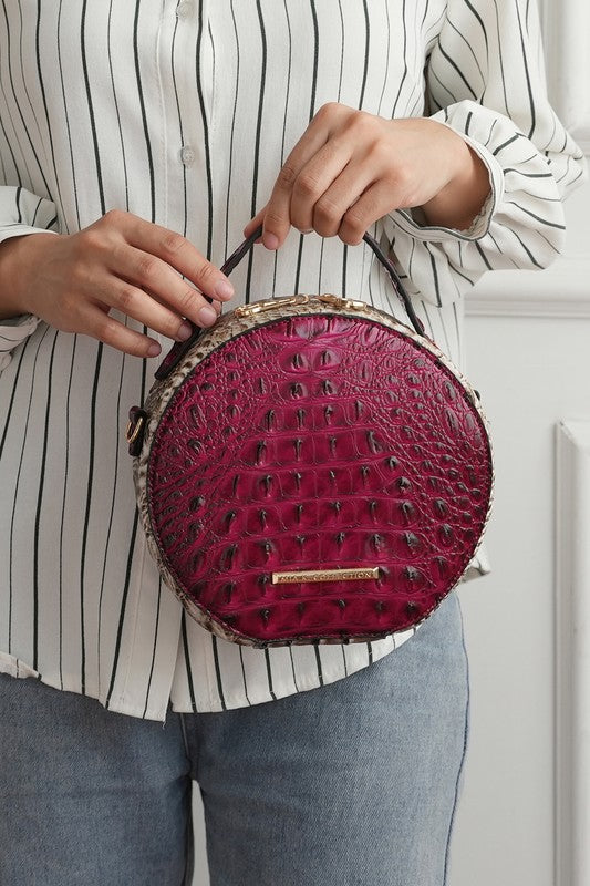 Croc-embossed round crossbody bag in fuchsia with gold bar front detail