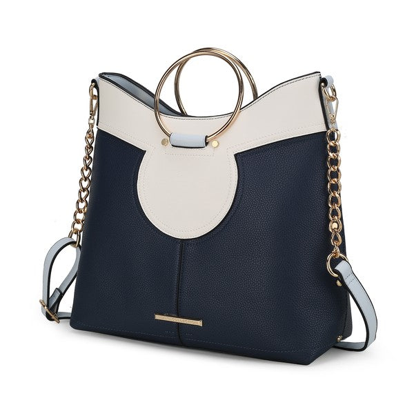 Navy blue and white top handle satchel with oval front cutout and adjustable shoulder strap.