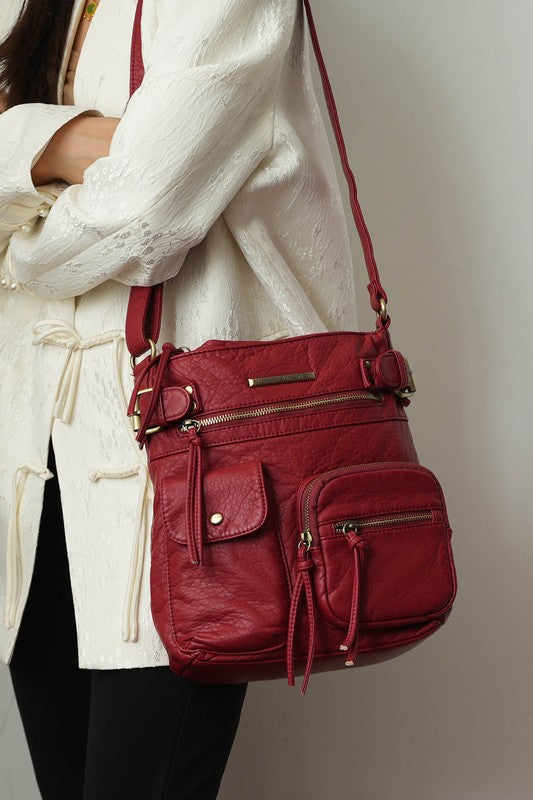 Burgundy leather crossbody bag with zip pockets and adjustable shoulder strap