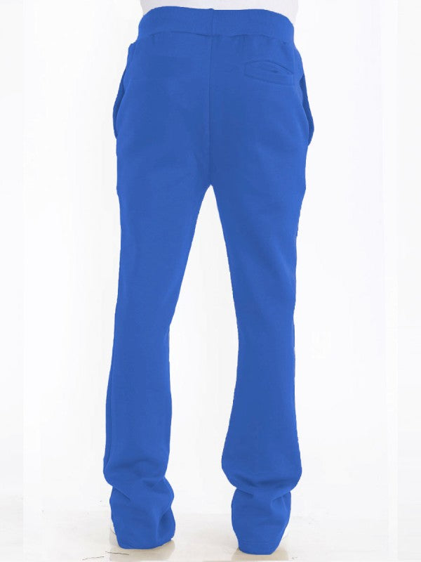 Solid blue track pants back view, rear yoke detail, stacked flare cuffs, drawstring waist