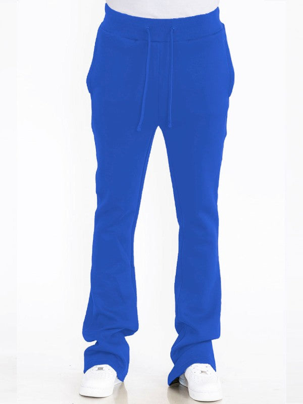 Solid blue track pants front view, drawstring waist, relaxed legs, stacked cuffs