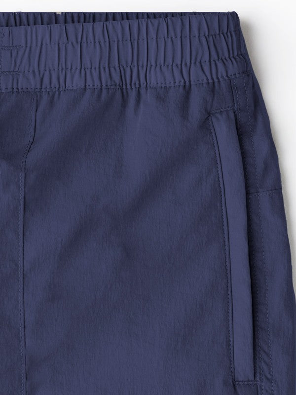 Close-up of men's navy nylon cargo pants waistband and pocket panel stitching