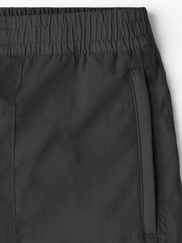 Close-up of men's black nylon cargo pants waistband and side seam stitching