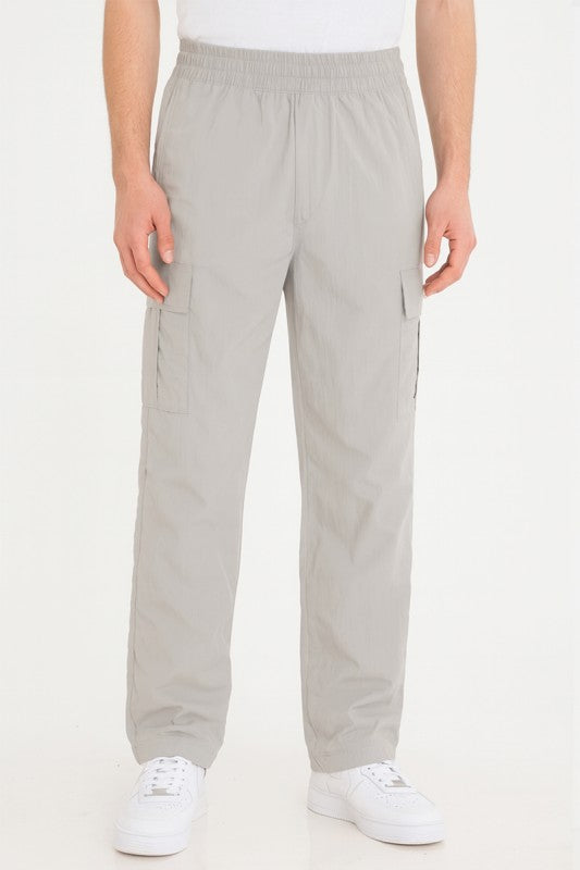 Light grey nylon cargo pants with cargo pockets, elastic waist, and straight legs