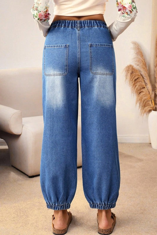 Blue denim barrel-leg jeans with elastic waist and back pockets, rear view