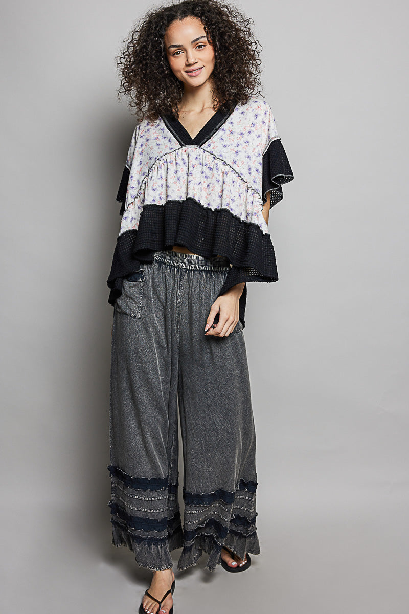 Floral print V-neck blouse with black contrast sleeves and layered ruffle hem