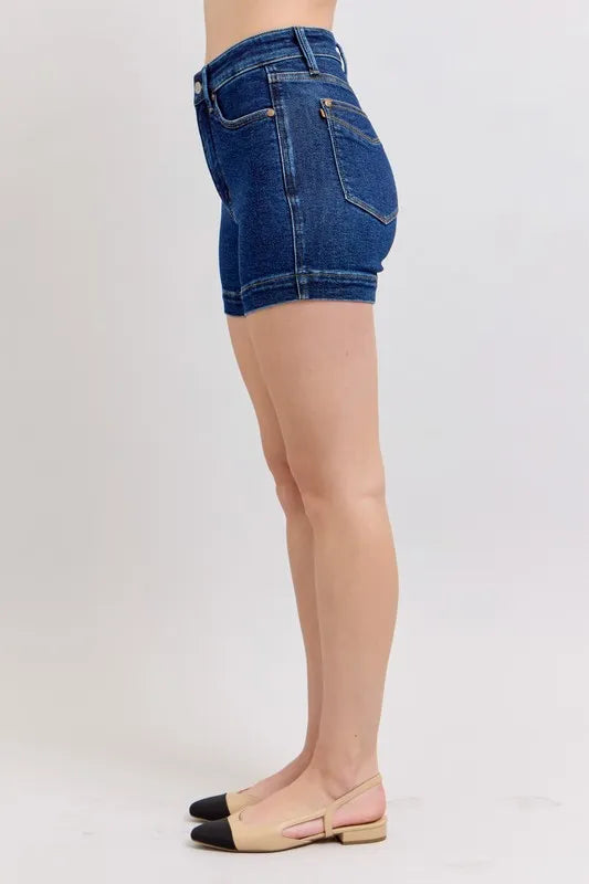 Dark blue denim shorts side/back view with belt loops and stitched seam details