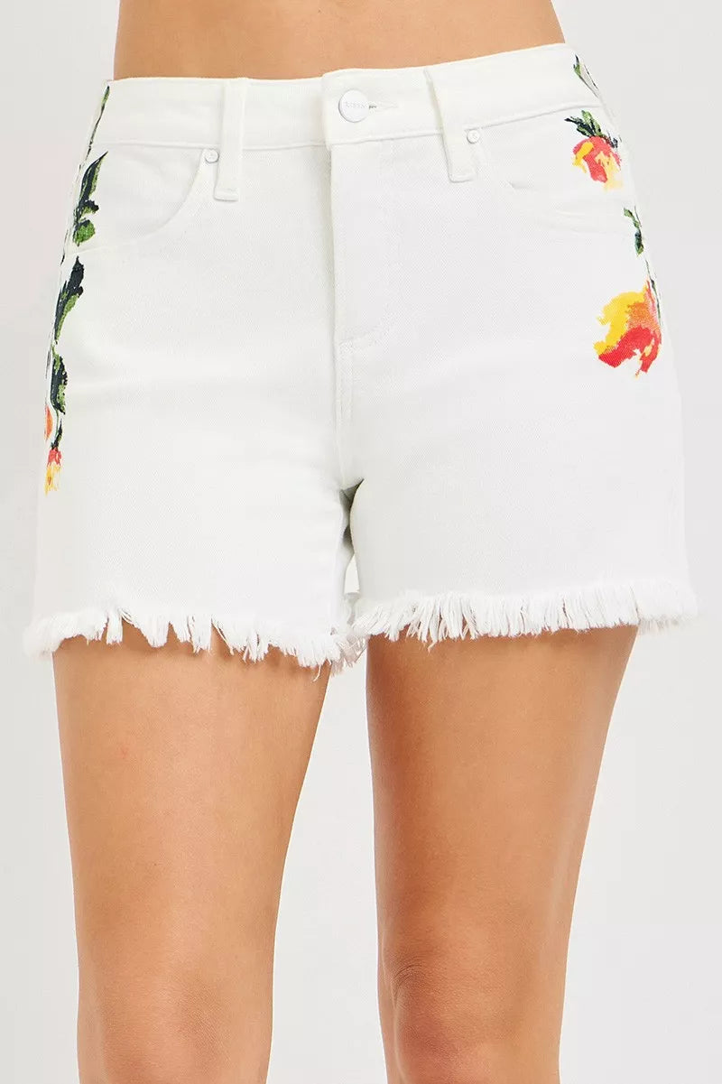 White high-rise shorts with floral print, frayed hem and button-front
