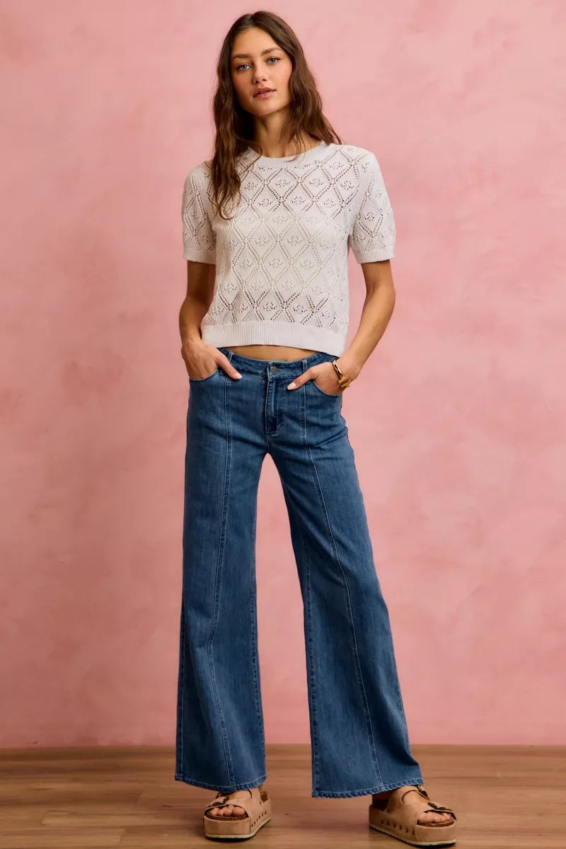 Denim wide-leg jeans with mid-rise waist, vertical seam detail, and patch pockets on back.