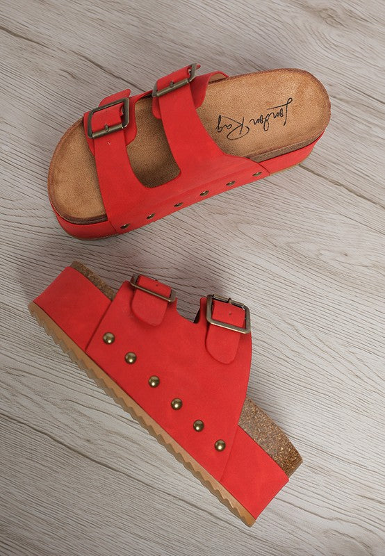 Red faux leather flatform sandals, top view of two buckle straps and stud trim