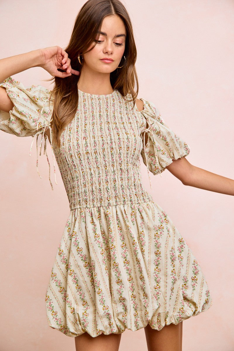 Ivory floral puff sleeve dress with bow tie accents and gathered skirt volume