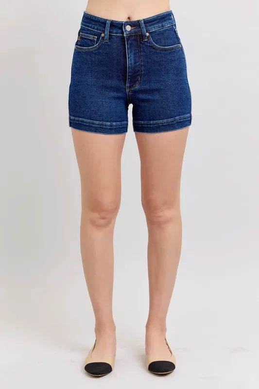 High-waist dark blue denim shorts, front view with two pockets and belt loops