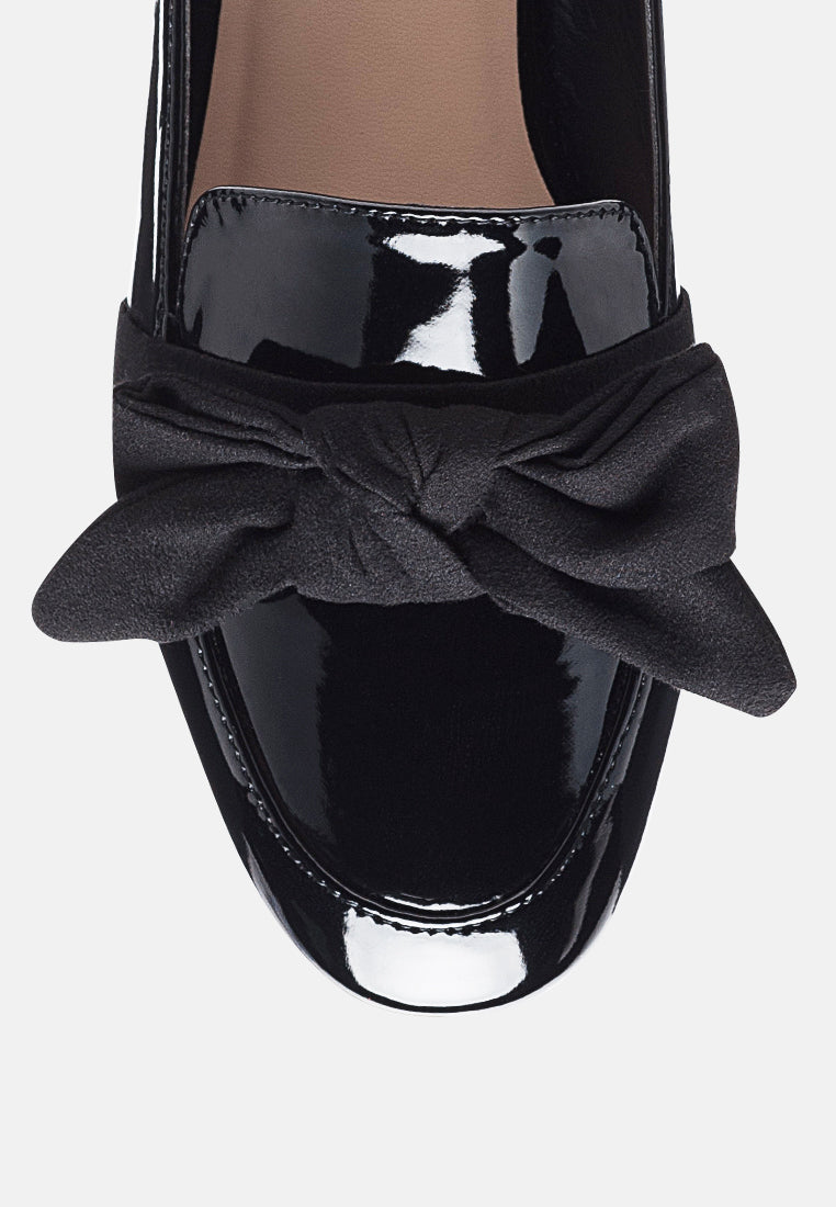 Black loafer top view with glossy vamp and large knotted fabric bow