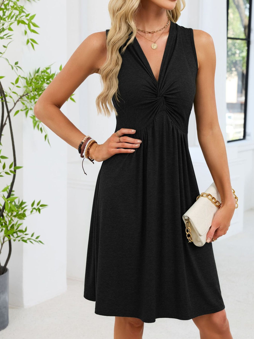 Black sleeveless twist-knot front dress with gathered skirt and V neckline