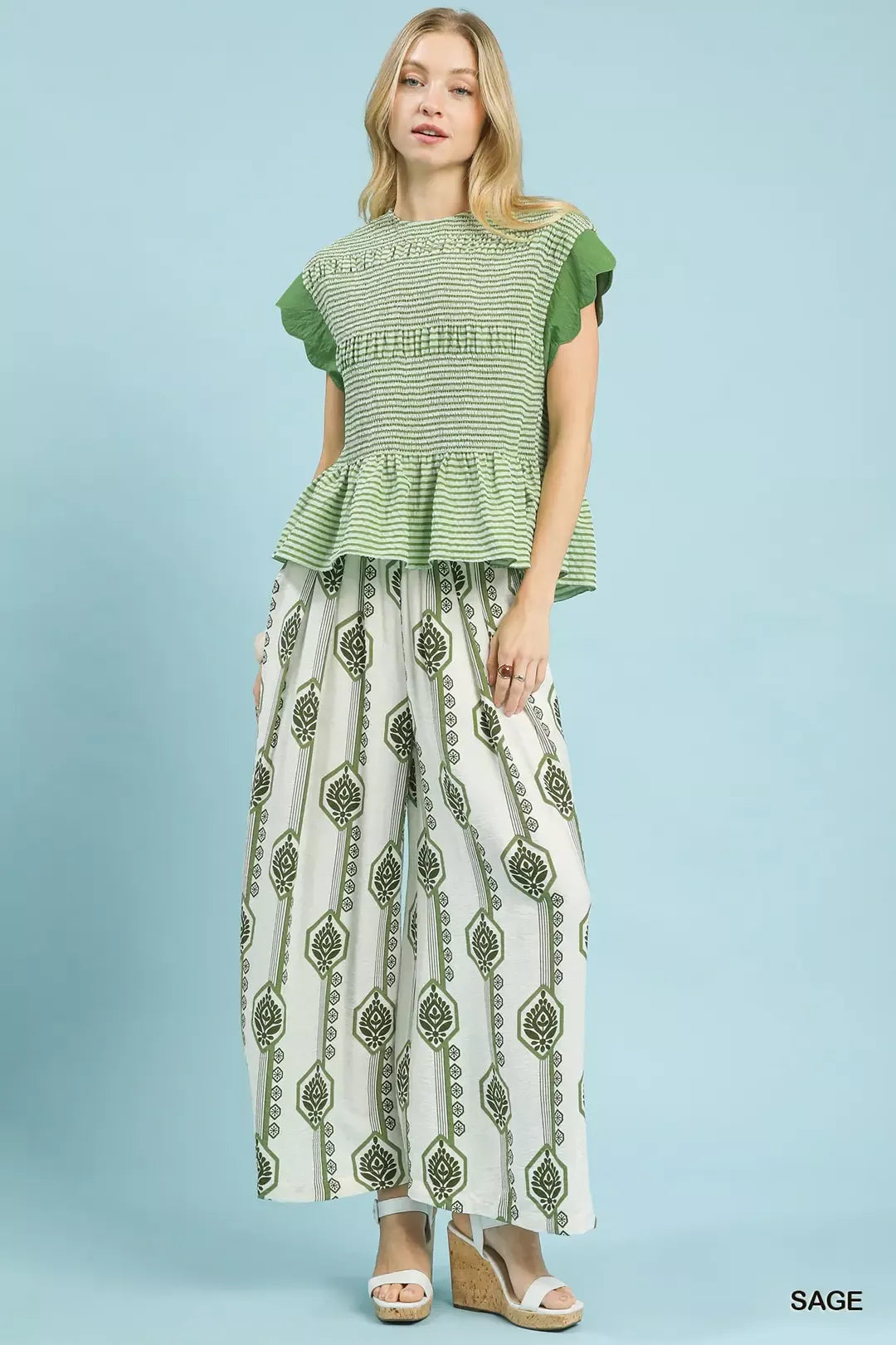 Weit geschnittene Boho-Hose in Salbei mit grünen Blumenornamenten auf hellem Grund